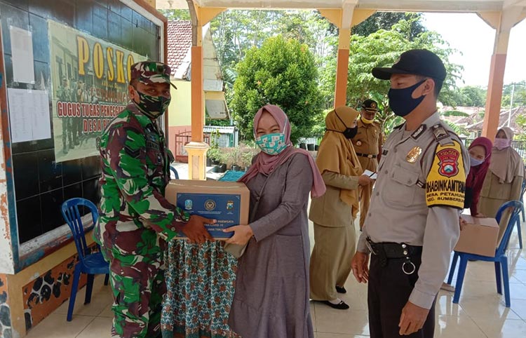 Babinsa Petahunan, Sertu Iswan Dewi Samsukdi saat melakukan pendampingan penyaluran bantuan.