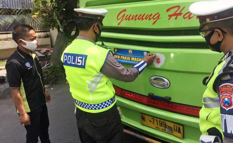 Petugas saat menempelkan stiker di bagian belakang bus Antar Kota Antar Provinsi (AKAP). foto: ist.
