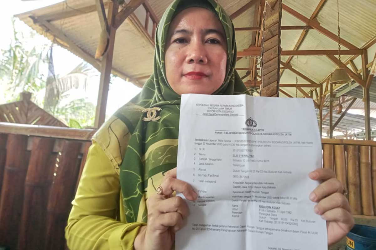 Korban Esya saat menunjukkan bukti laporannya ke awak media.