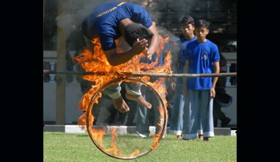 Atraksi mandi api dengan posisi mata ditutup. foto: rony suhartomo/ BANGSAONLINE
