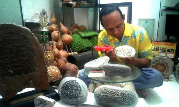 Bagus Heri Setiadji sedang mengukir batu. foto: Disna/BANGSAONLINE