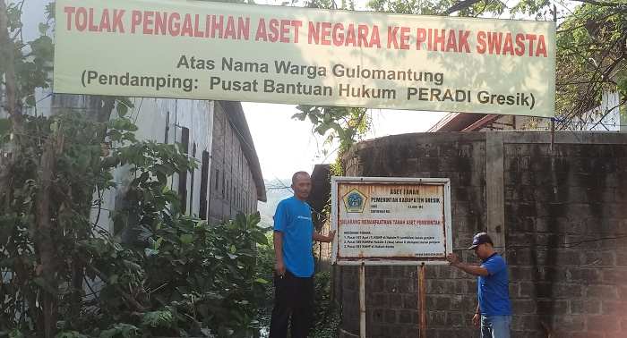 Ketua RT 7 RW 2 Desa Gulomantung, Achmad Zainul Agus (kiri) bersama warga menunjukkan aset pemerintah yang akan disewakan ke swasta. Foto: SYUHUD/ BANGSAONLINE.com