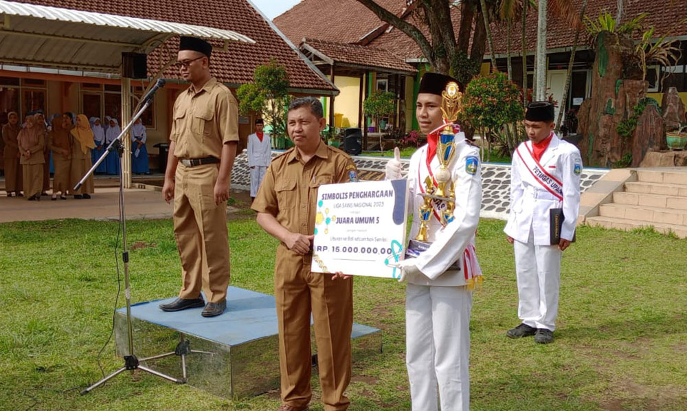 Kepala SMAN Pronojiwo Ade Wartono saat menyerahkan trofi secara simbolis kepada Gilang, Senin (27/11/23).