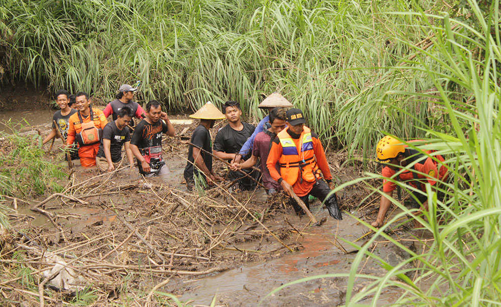 Tim gabungan dibantu warga saat susur sungai melakukan pencarian terhadap korban. foto: RAFLI FAJRI JULIANTO/ BANGSAONLINE