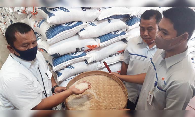 Kepala Perum Bulog Cabang Kediri Mara Kamin Siregar (kiri), menunjukkan contoh beras yang akan didistribusikan kepada KPM di Kabupaten Kediri, Kota Kediri, dan Kabupaten Nganjuk. foto: MUJI HARJITA/ BANGSAONLINE
