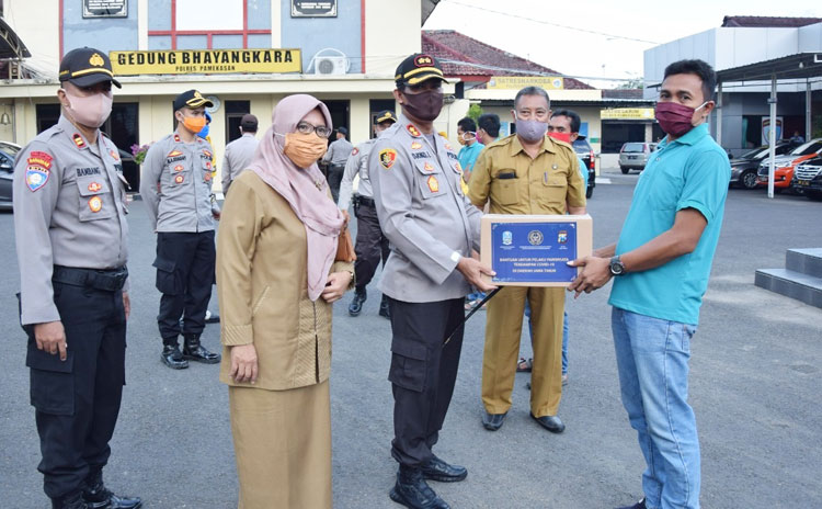 Kapolres Pamekasan AKBP Djoko Lestari saat menyerahkan bantuan paket sembako dari Kemenpar kepada pelaku pariwisata yang terdampak Covid-19. 