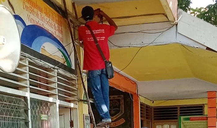 Petugas tampak memasang CCTV di salah satu sudut sekolah.