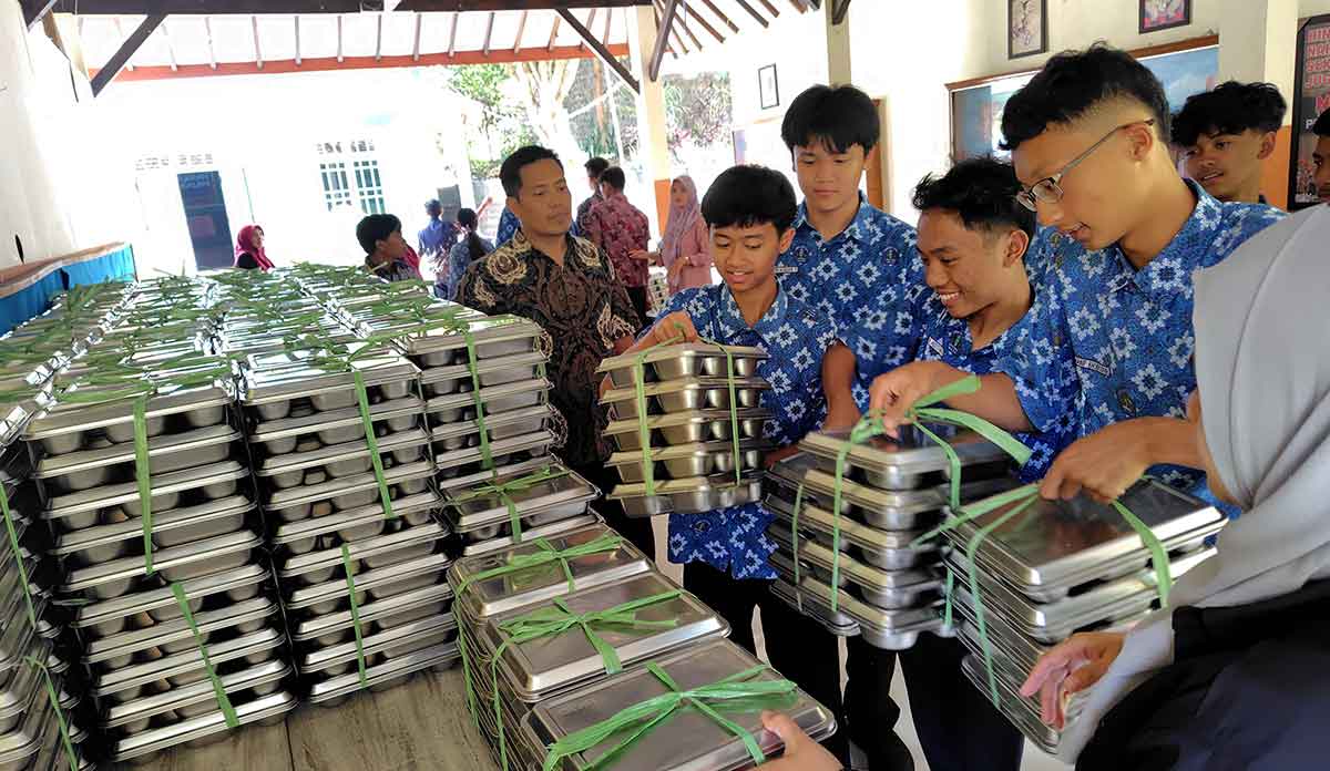 Siswa SMAN 2 Batu saat mengambil MBG untuk didistribusikan kepada teman-temannya di kelas.