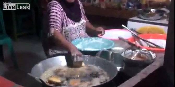 Ibu-ibu yang menggemparkan dunia maya karena membolak balikkan gorengan dengan tangan kosong. foto via merdeka.com