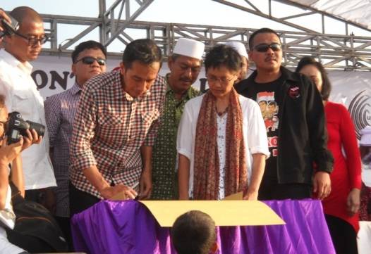 TEKEN – Capres Jokowi saat meneken kontrak politik di atas tanggul lumpur titik 21, di Desa Siring Porong, Sidoarjo, Kamis (29/5/2014). foto : musta’in/BangsaOnline


