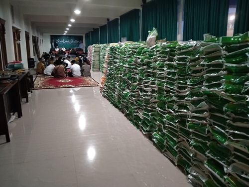 Tumpukan beras ini terus berganti. Begitu diangkut oleh para relawan, beras baru datang lagi.  Beras ini ditaruh di Guest House kampus Institut KH Abdul Chalim Pondok Pesantren Amanatul Ummah Pacet Mojokerto Jawa Timur. Beras ini difoto BANGSAONLINE.COM pada Senin (18/5/2020) malam. Foto: MMA/bangsaonline.com    