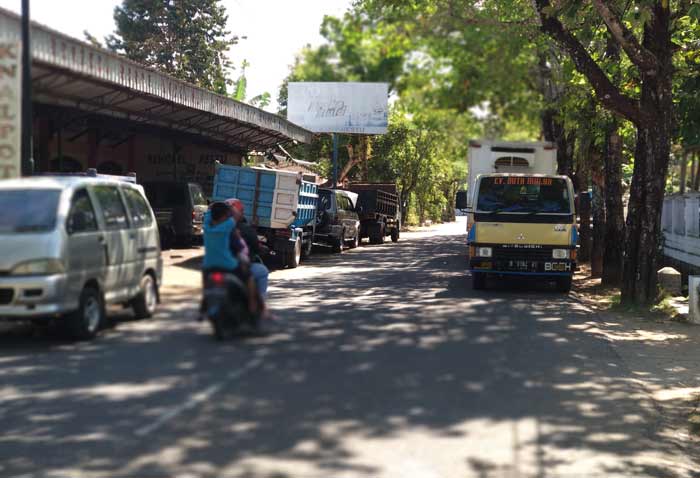 Tampak mobil-mobil pelanggan bengkel depan Dinkes Pacitan yang parkir hingga di dua sisi bahu jalan. foto: YUNIARDI S/ BANGSAONLINE