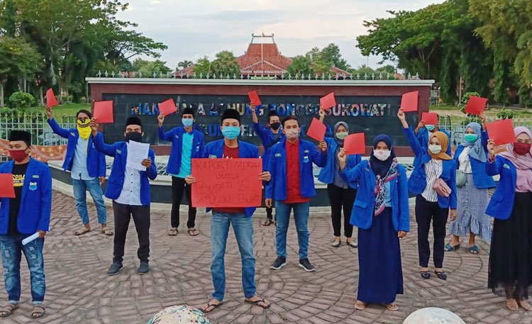 Puluhan massa PMII melakukan aksi diam sambil menyampaikan raport merah pemerintahan Baddrut Tamam-Raja