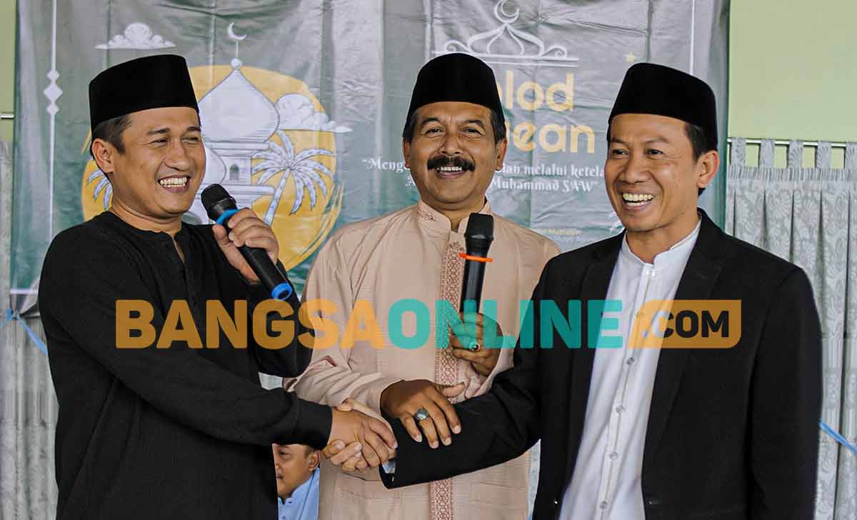 Ketua Keluarga Bawean Malang, Afys El Syarief Imajiner, saat bersalaman dengan Taufikurrahman, ketua sebelumnya. Foto: AGUS SALIMULLAH/BANGSAONLINE