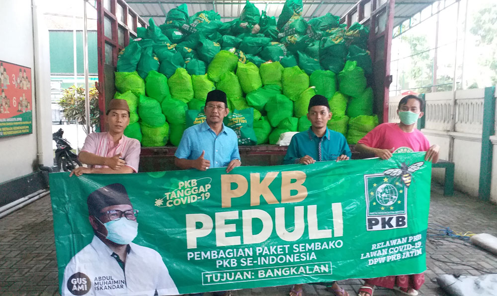 Ketua DPC PKB Bangkalan Ir. Mondir Rofii bersama para pengurus DPC foto dengan latar belakang paket sembako bantuan dari Ketum PKB. foto: SUBAIDAH/ BANGSAONLINE