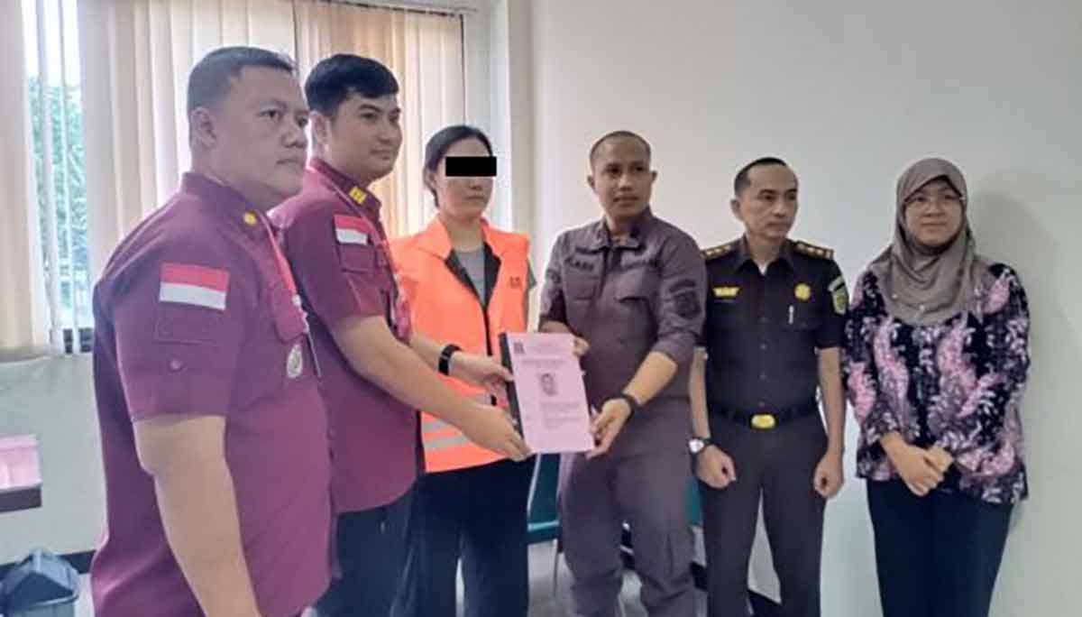 Petugas Imigrasi Surabaya menyerahkan berkas kasus WN Tiongkok yang menjadi joki Bahasa Inggris ke Kejari Surabaya. Foto: Ist