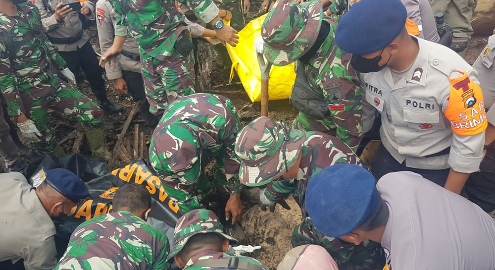 Petugas saat mengevakuasi jenazah korban banjir bandang di Kota Batu.