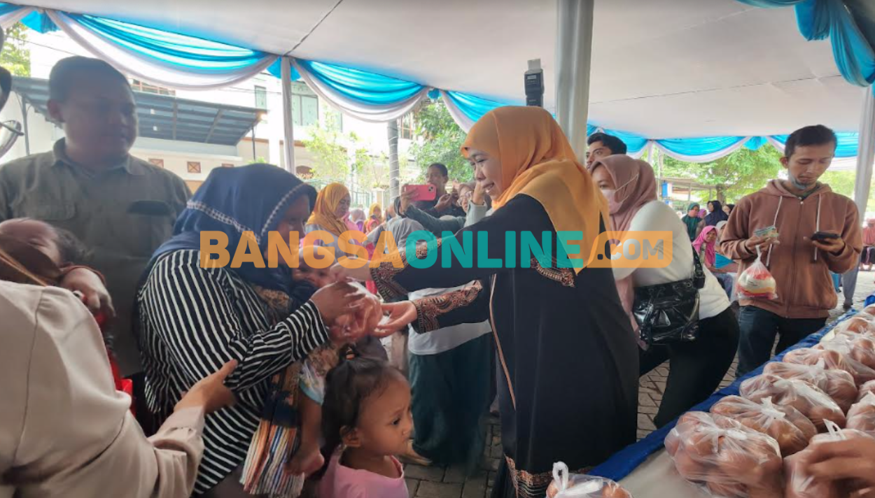 Khofifah Indar Parawansa saat membagikan membagikan telur gratis untuk anak-anak. Foto: Devi Fitri Afriyanti