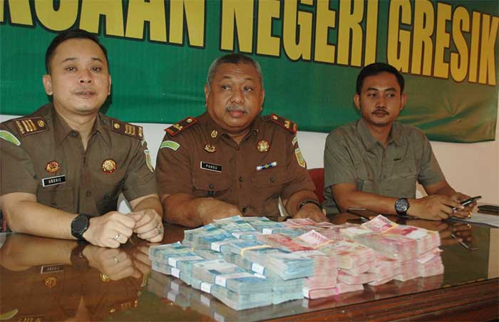 Kajari Gresik Pandu Pramoekartika didampingi Kasi Pidsus Andrie Dwi Subianto saat menerima pengembalian uang korupsi BJPS. foto: SYUHUD/ BANGSAONLINE