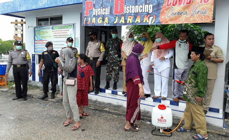 Satkoryon Banser Giligenting saat berpartisipasi menjaga Posko Covid-19.