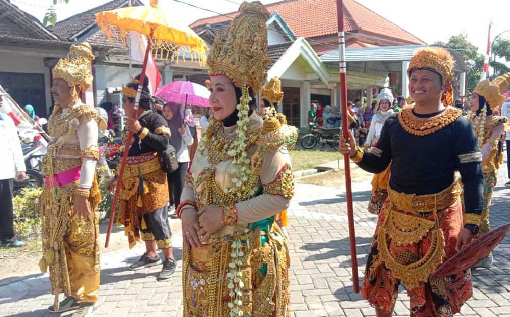 Kades Kedungpring, Priyono beserta istri, memakai kostum Kerajaan Majapahit saat mengikuti karnaval. Foto: SYUHUD/ BANGSAONLINE