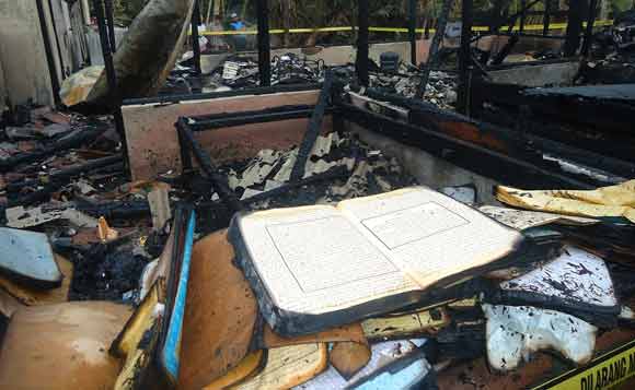 AJAIB: Sebuah Al-Quran masih tampak utuh meski satu buah bangunan rumah beserta perobatan rumah tangga ludes terbakar. Foto: Eky Nurhadi/BANGSAONLINE