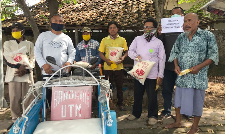 Relawan Bangkalan Tanggap (RBT) Covid-19 saat memberikan bantuan berupa beras dan minyak goreng kepada tukang becak.