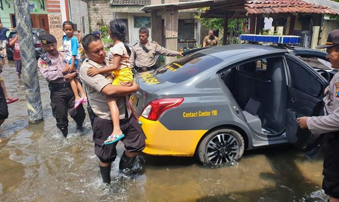 Terdampak Banjir, Kapolsek Taman dan Anggota Evakuasi Anak Sekolah Terdampak Banjir, Kapolsek Taman dan Anggota Evakuasi Anak Sekolah