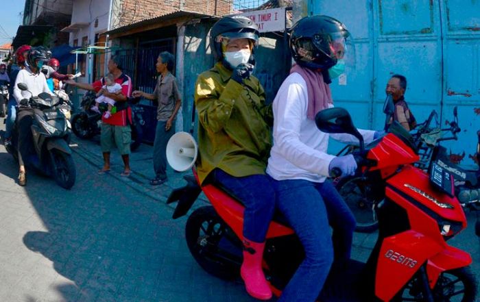 ​Bonceng Sepeda Motor, Risma Bagikan Masker dan Sosialisasi Protokol Kesehatan