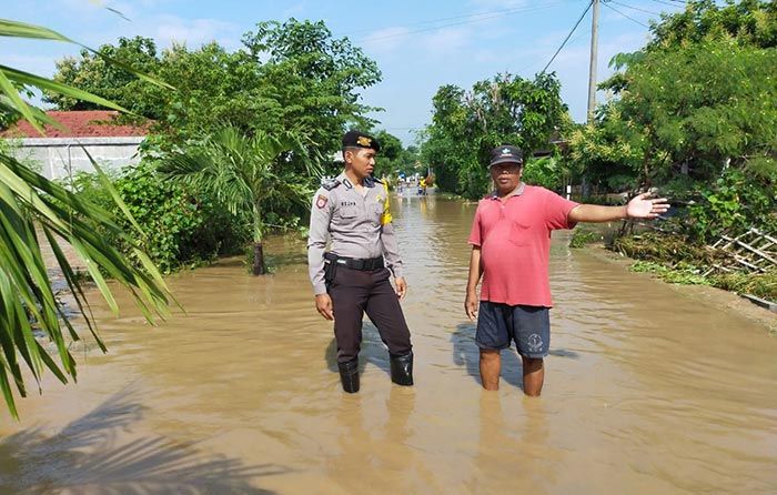 Turun ke Lokasi Banjir, Bhabinkamtibmas Pakunden Ponorogo Imbau Warga Tetap Waspada