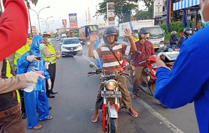 Cegah COVID-19, Satlantas Polres Pasuruan Sosialisasi dan Semprotkan Disinfektan pada Pengendara