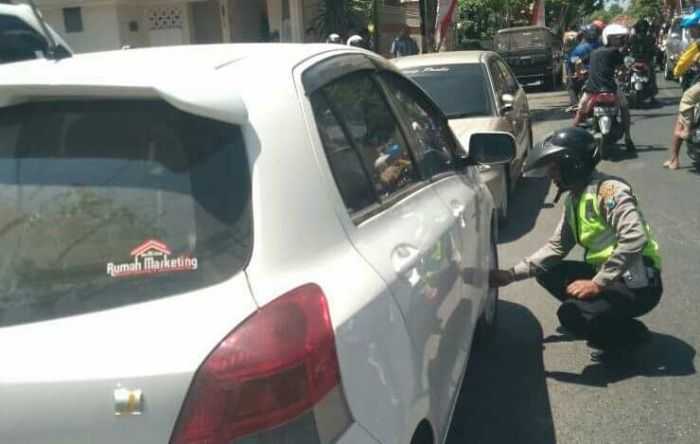 Polres Pamekasan Gembosi Mobil yang Parkir Sembarangan di Jalan Mandilaras