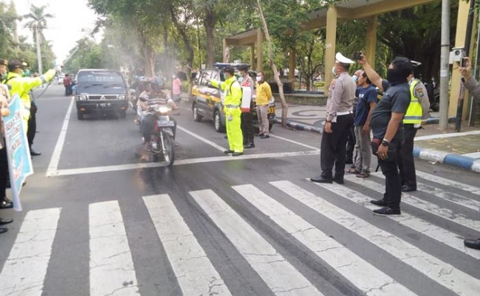 Polres Jombang Sebar Maklumat Kapolri dan Semprotkan Cairan Disinfektan pada Pengguna Jalan