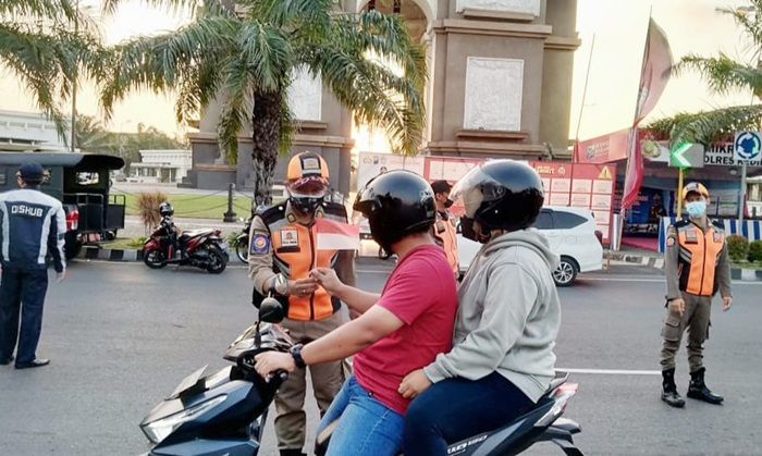 Jelang HUT RI, Petugas Gabungan di Kediri Bagikan Bendera Merah Putih kepada Pengguna Jalan