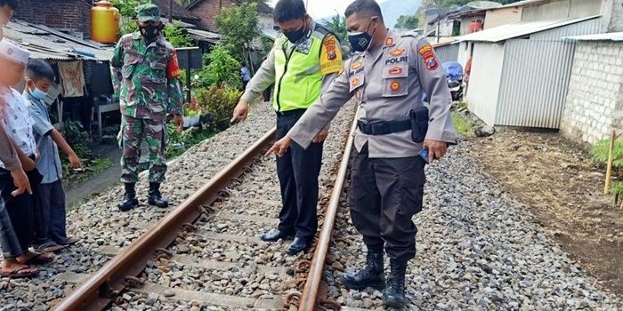 Polisi bersama warga sedang menunjuk ke titik lokasi kecelakaan.