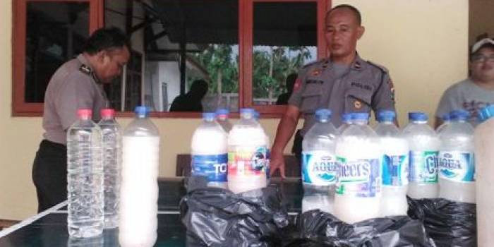 MIRAS: Anggota Polsek Kota Bojonegoro sedang menunjukan barang bukti puluhan liter miras hasil grebekan di beberapa warung sekitar kota. Foto: Eky Nurhadi/Bangsaonline.com