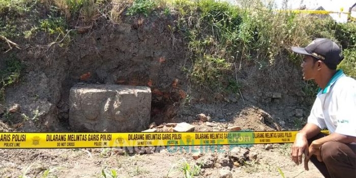 Salah seorang warga yang penasaran melihat arca berbentuk kepala manusia yang ditemukan di Kelurahan Gedog, Kecamatan Sananwetan, Kota Blitar.