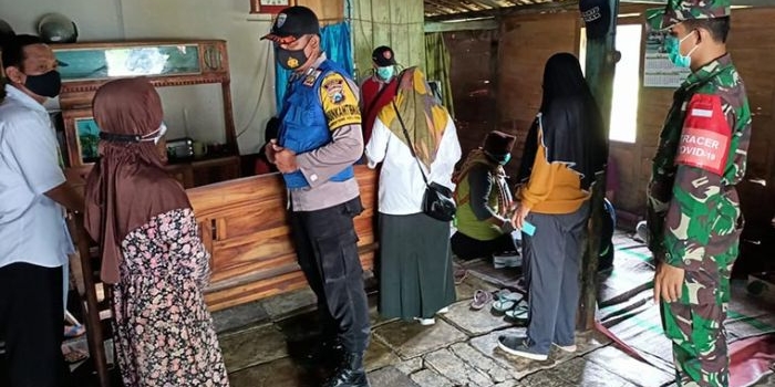 Petugas mengecek warga desa yang diduga mengalami keracunan usai menyantap nasi kotak yang didapat dari acara hajatan.