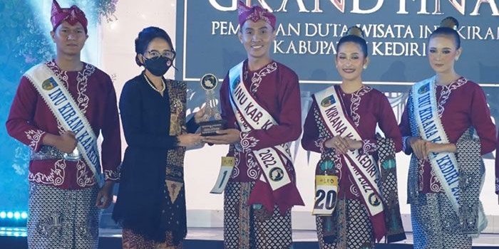 Ketua Dekranasda Kabupaten Kediri, Eriani Annisa Hanindhito, saat menyerahkan piala kepada Praska Arwi Restanto dan Aida Fathiyya yang terpilih menjadi juara pertama Duta Wisata Inu Kirana Kabupaten Kediri 2022. Foto: Ist