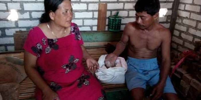 Pujiati bersama suaminya saat menunjukkan raskin yang berkutu dan bubukan. foto: suwandi/BANGSAONLINE