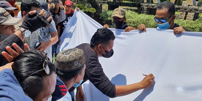LSM Lira Kabupaten Probolinggo menggelar aksi penggalangan dukungan terhadap KPK dengan pembumbuhan tanda tangan di depan Kantor Bupati di Kraksaan Probolinggo, Selasa (31/8/2021). foto: Andi Sirajudin/ Bangsaonline.com