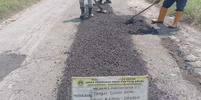 Tim URC Bima DPUTR Gresik ketika melakukan perbaikan Jalan Betoyo-Tanggulrejo, Manyar. foto: SYUHUD/BANGSAONLINE