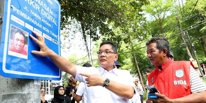 Pemasangan dilakukan melalui metode foto langsung di lokasi, kemudian dicetak, dan ditempel pada rambu kawasan parkir digital. Foto: Hms