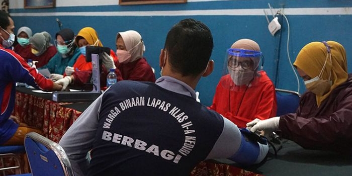 Petugas Dinas Kesehatan Kota Kediri saat mengecek tekanan darah salah satu peserta vaksinasi dari warga binaan Lapas Kelas IIA Kediri. (foto: ist)