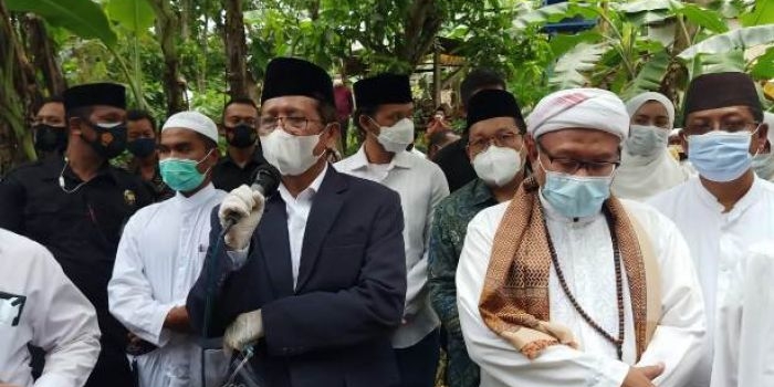 Menko Polhukam Mahfud MD saat memberikan sambutan dalam acara pemakaman kakak tertuanya Hj Daifah Siti Aisyah di Pamekasan Madura, Sabtu (19/12/2020). Tampak juga KH Ali Karrar, tokoh agama Pamekasan Madura. Foto: ist