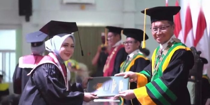 Rektor IIKNU Tuban, Miftahul Munir saat mewisuda salah seorang mahasiswi di prosesi wisuda ke VII