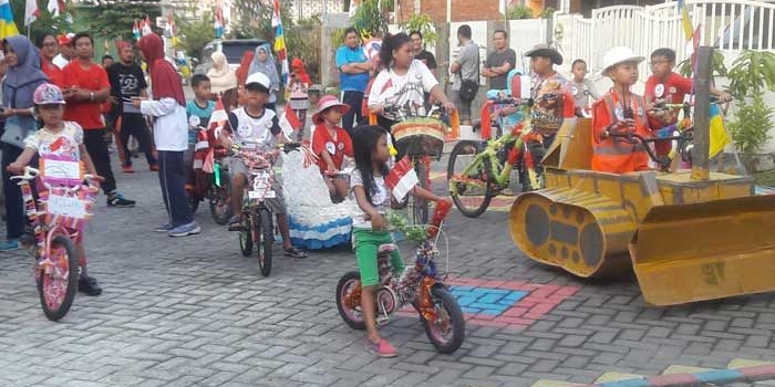 Anak-anak Perumahan Kembangan memamerkan sepedanya yang sudah dihias dalam lomba peringatan HUT Kemerdekaan RI ke-74 tahun 2018. foto: SYUHUD/ BANGSAONLINE