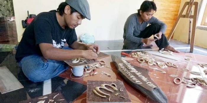Mustamil saat menunjukkan cara pembuatan kaligrafi dari bambu. foto: RONY S/ BANGSAONLINE