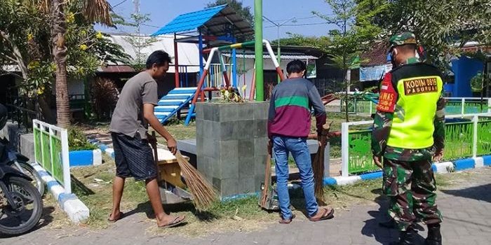 Para pelanggar protokol kesehatan saat membersihkan sarana fasilitas umum. (foto: ARDIANZAH/ BANGSAONLINE)