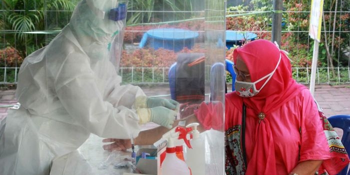 Petugas medis berpakian APD lengkap saat melakukan rapid test kepada warga. (foto: ist.)